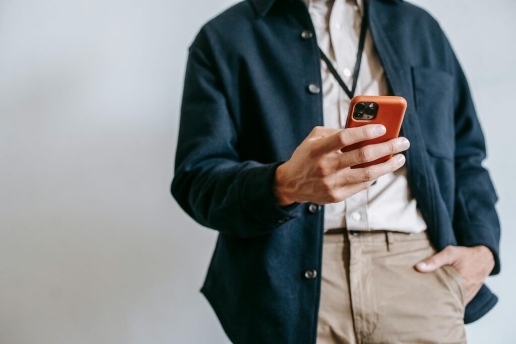 pexels-photo-5745183-5745183 A man in casual attire browsing on a smartphone indoors, showcasing modern tech lifestyle.